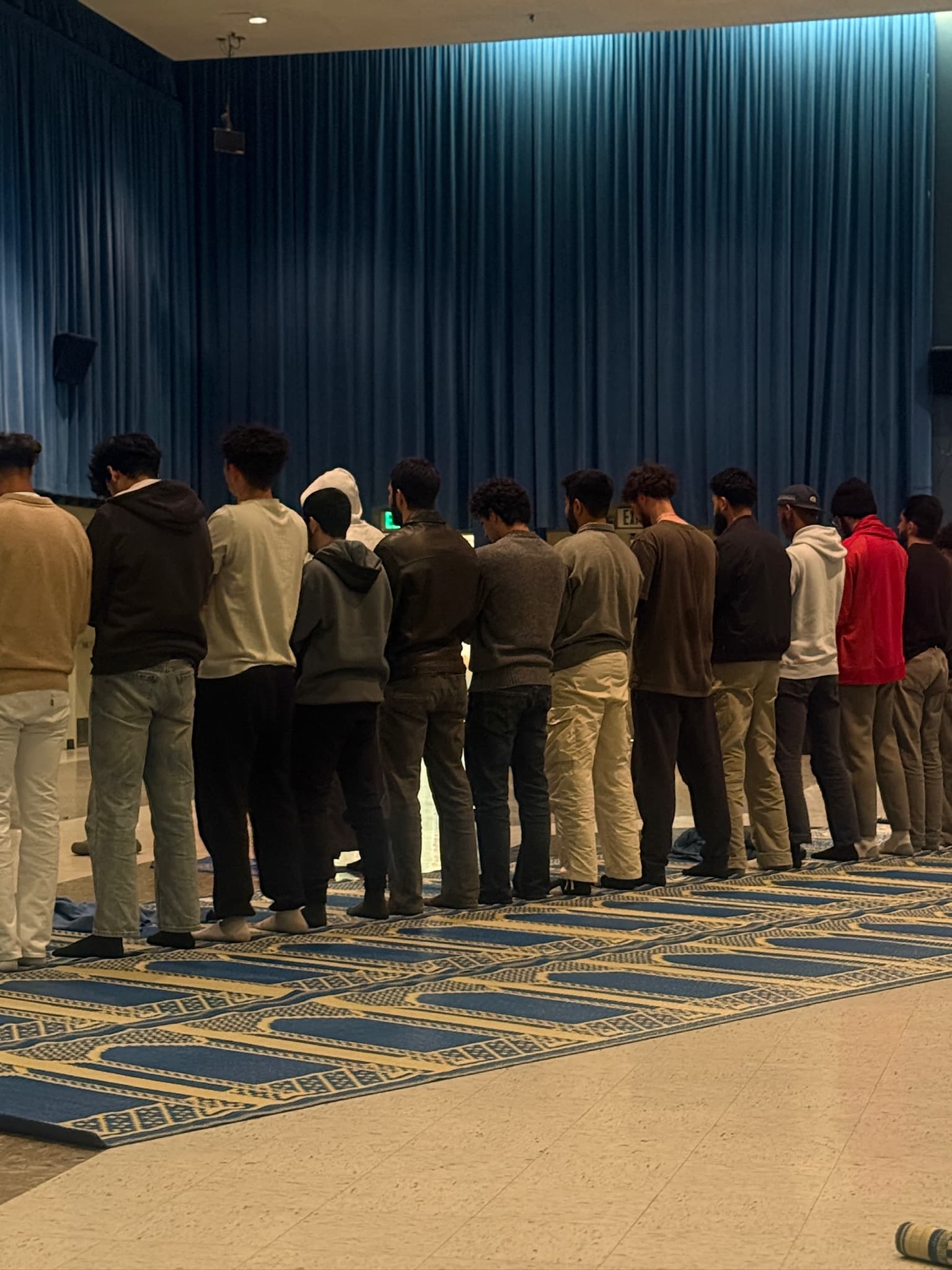 A group of Muslim men praying in Ackerman Grand Ballroom at UCLA.