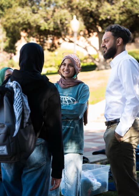 A group of Muslim students talking on a brigt sunny day.